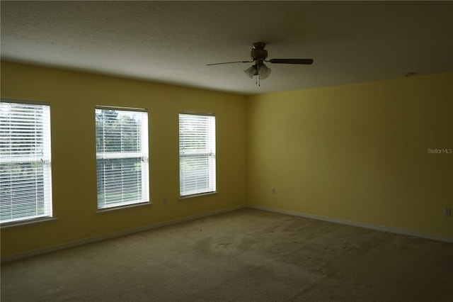 carpeted spare room with ceiling fan and a textured ceiling