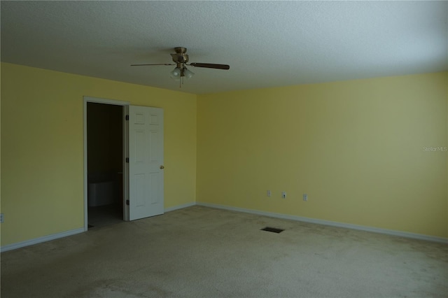 carpeted empty room with ceiling fan and a textured ceiling