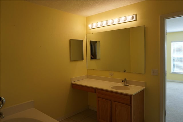 bathroom with vanity, a bath, tile patterned flooring, and a textured ceiling