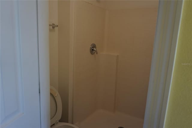 bathroom featuring toilet and tiled shower