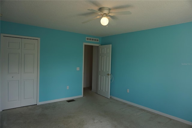 unfurnished bedroom featuring carpet floors, a textured ceiling, ceiling fan, and a closet