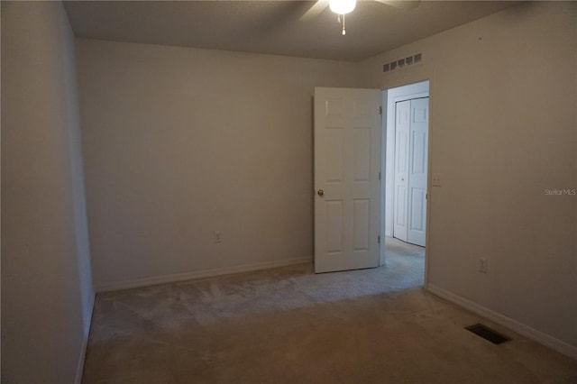 carpeted spare room featuring ceiling fan