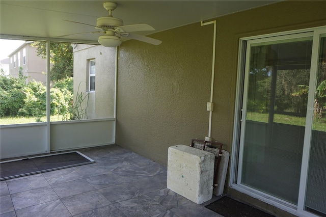 unfurnished sunroom featuring ceiling fan