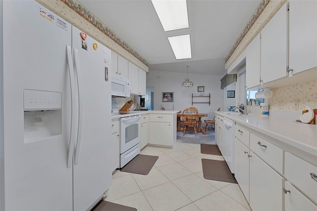 kitchen featuring white cabinets, kitchen peninsula, white appliances, backsplash, and decorative light fixtures