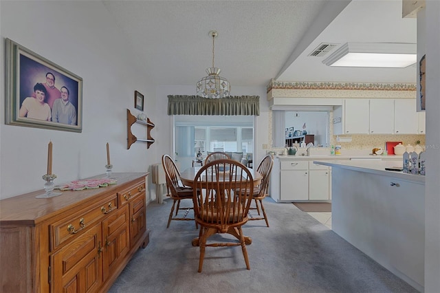 carpeted dining area featuring a textured ceiling and a chandelier