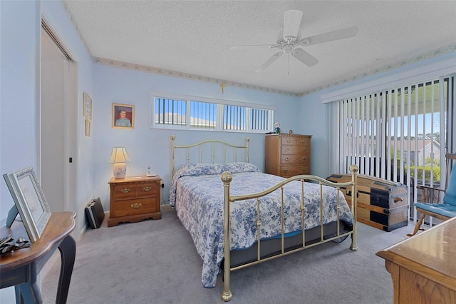 bedroom featuring ceiling fan, a textured ceiling, light carpet, and multiple windows