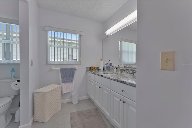 bathroom with tile patterned flooring, vanity, toilet, and plenty of natural light