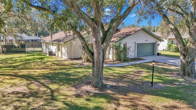 exterior space with a front yard, a garage, and cooling unit