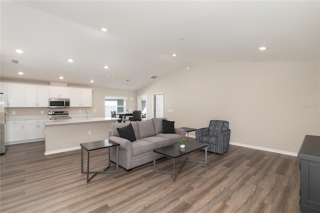 living area featuring recessed lighting, baseboards, wood finished floors, and vaulted ceiling