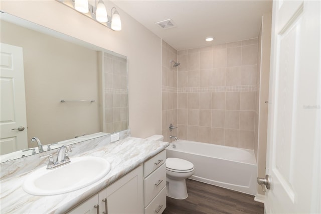 full bath with visible vents, toilet, shower / tub combination, wood finished floors, and vanity