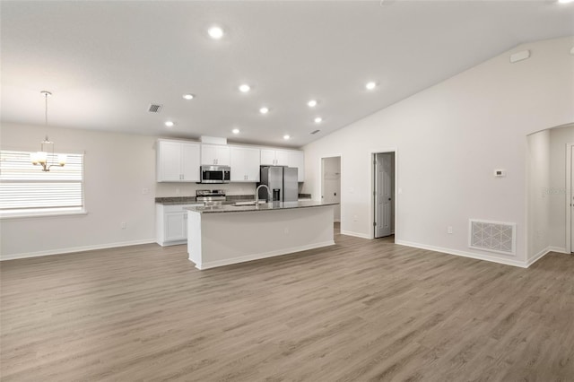 kitchen with light wood-type flooring, stainless steel appliances, a kitchen island with sink, and white cabinets