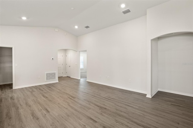 unfurnished room featuring lofted ceiling and dark hardwood / wood-style floors