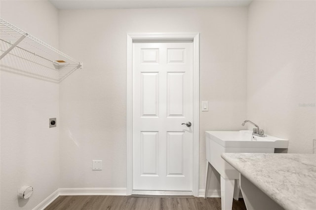 washroom with wood-type flooring and hookup for an electric dryer