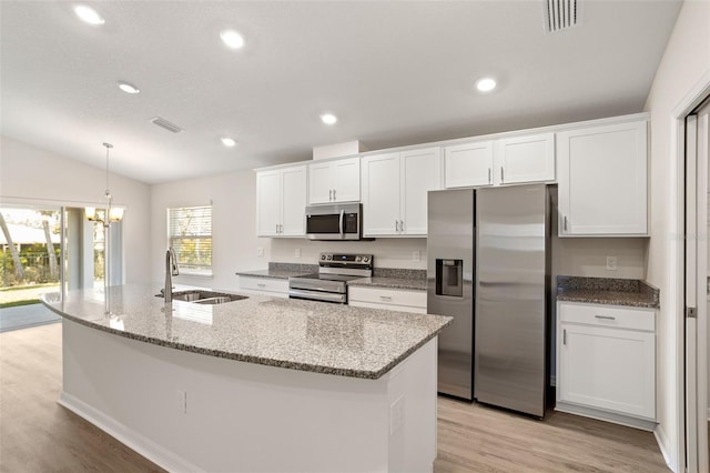 kitchen featuring stainless steel appliances, sink, a center island with sink, and white cabinets