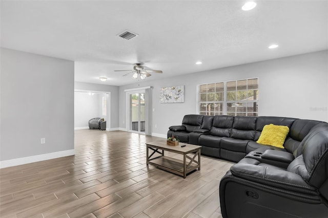 living room with light hardwood / wood-style flooring and ceiling fan