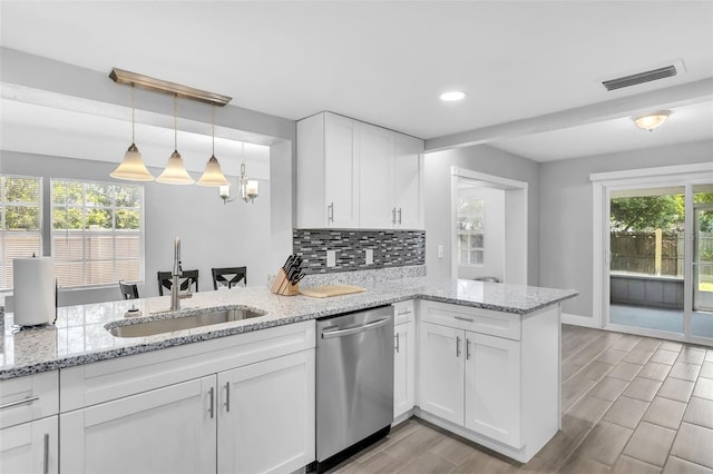 kitchen featuring dishwasher, plenty of natural light, sink, white cabinetry, and kitchen peninsula