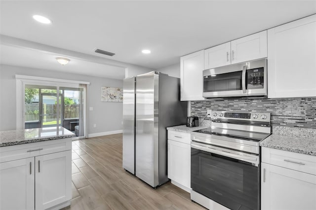 kitchen featuring light hardwood / wood-style floors, white cabinetry, tasteful backsplash, light stone countertops, and stainless steel appliances