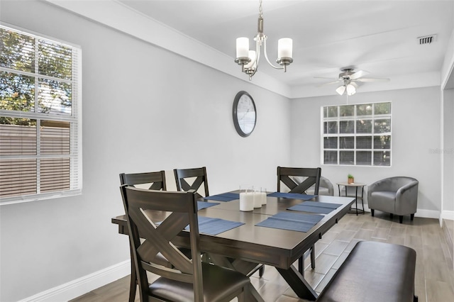 dining area featuring ceiling fan with notable chandelier and hardwood / wood-style floors