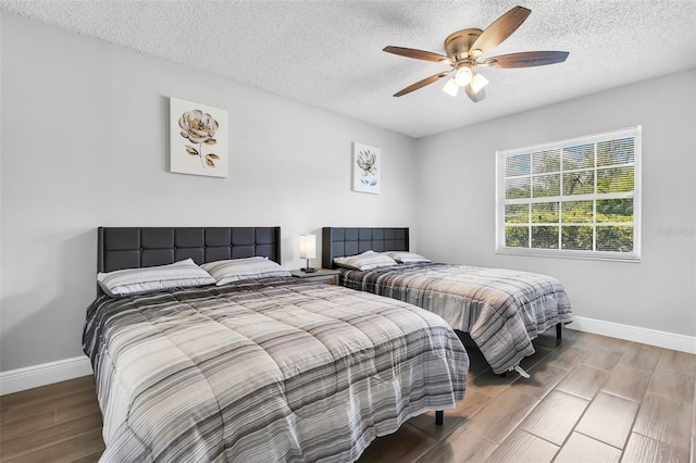 bedroom with wood-type flooring, ceiling fan, and a textured ceiling