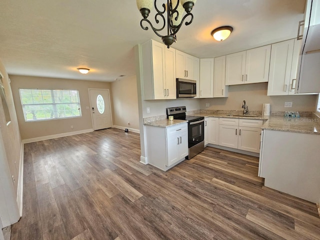 kitchen featuring white cabinets, pendant lighting, sink, dark wood-type flooring, and appliances with stainless steel finishes