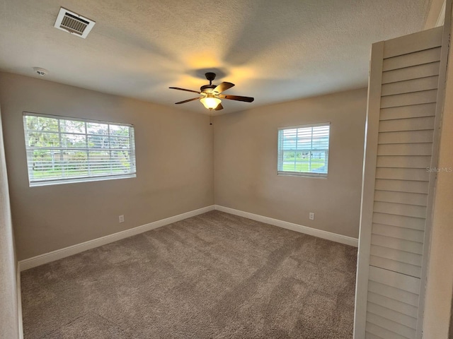 carpeted spare room with ceiling fan and a textured ceiling