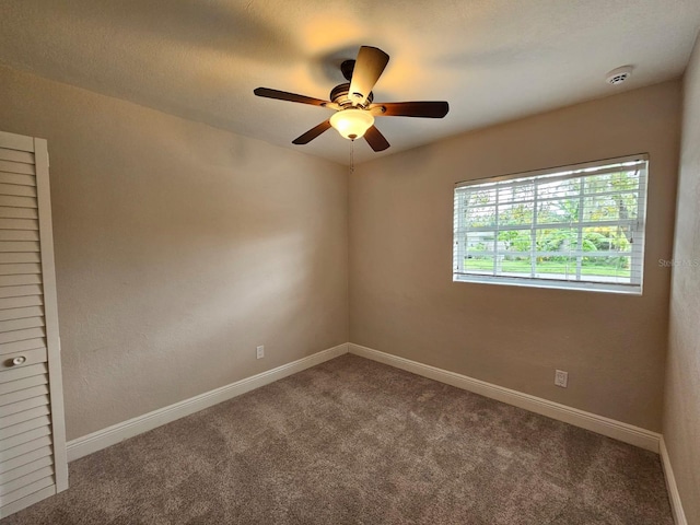 spare room with carpet and ceiling fan