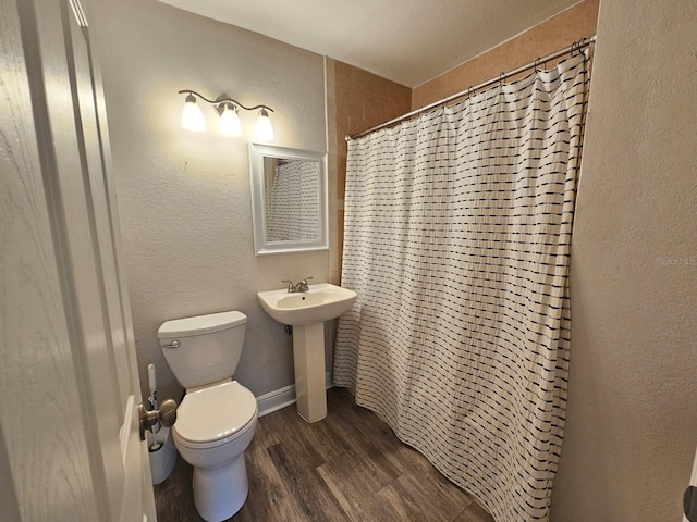 bathroom featuring wood-type flooring, toilet, and sink