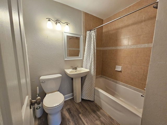 full bathroom featuring wood-type flooring, shower / bath combination with curtain, sink, and toilet