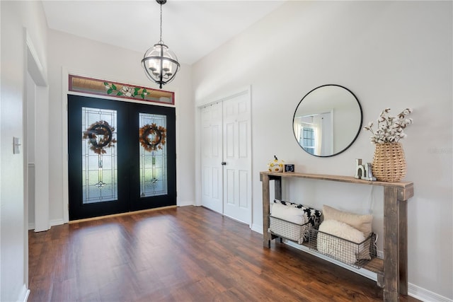 entryway featuring french doors, dark hardwood / wood-style flooring, and a notable chandelier