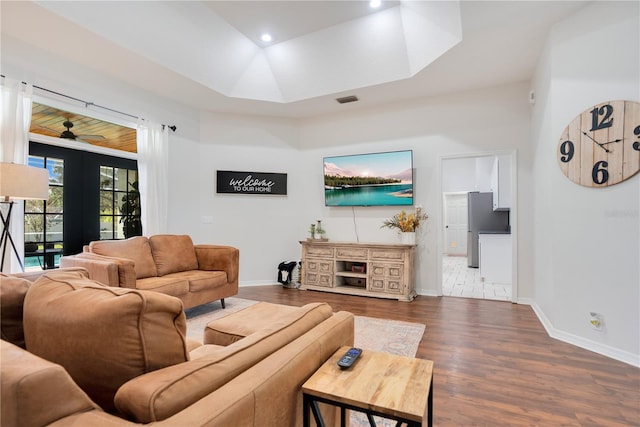 living room featuring dark wood-type flooring and ceiling fan