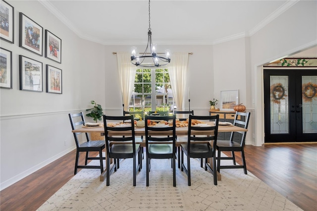 dining room with french doors, ornamental molding, wood-type flooring, and an inviting chandelier