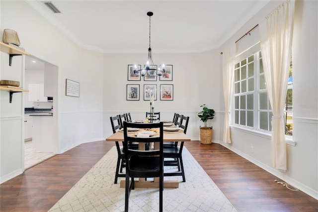 dining room featuring ornamental molding, dark hardwood / wood-style floors, and an inviting chandelier