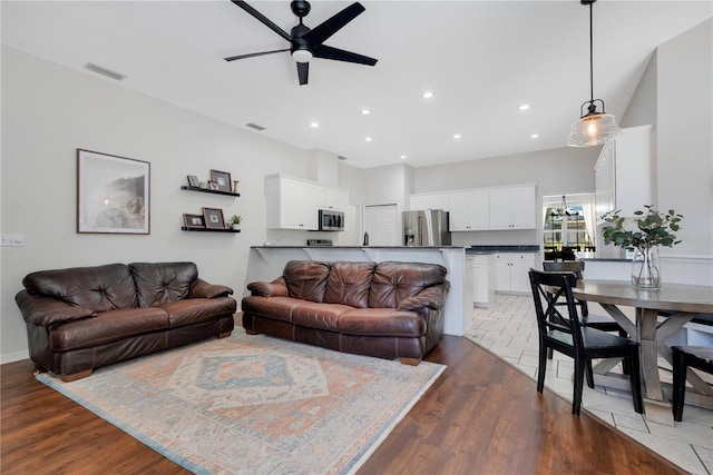 living room featuring ceiling fan and dark hardwood / wood-style floors