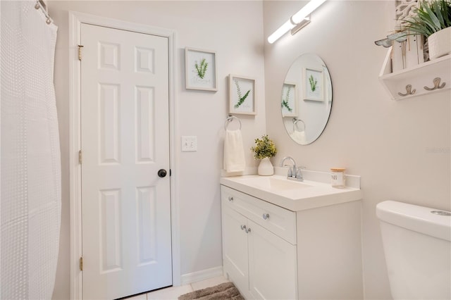 bathroom featuring vanity, tile patterned flooring, and toilet