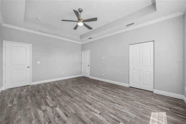 unfurnished room with ceiling fan, ornamental molding, a tray ceiling, and hardwood / wood-style floors