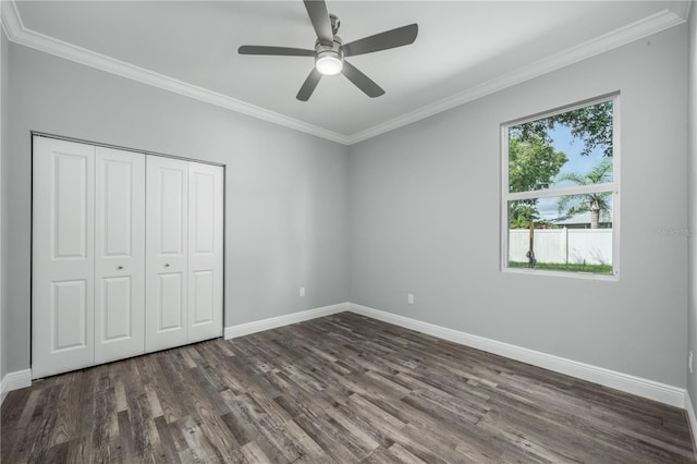 unfurnished bedroom featuring ornamental molding, dark wood-type flooring, a closet, and ceiling fan