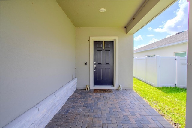 view of exterior entry featuring a lawn