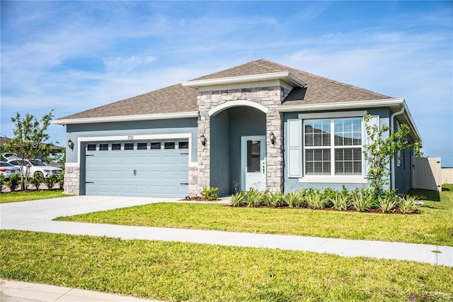 view of front of property with roof with shingles, a garage, driveway, and a front lawn