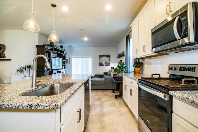 kitchen with open floor plan, visible vents, decorative backsplash, stainless steel appliances, and a sink