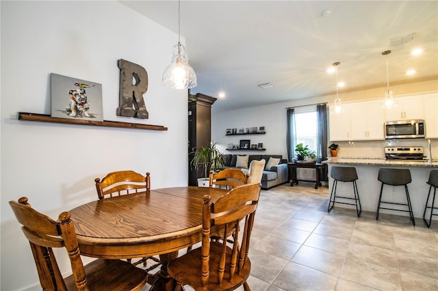 dining space featuring light tile patterned flooring and recessed lighting