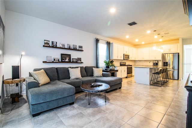 living area with light tile patterned floors and visible vents