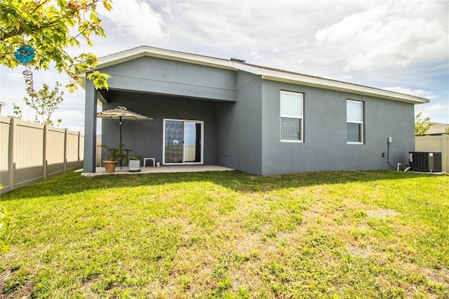 rear view of house featuring a yard, a fenced backyard, stucco siding, a patio, and central AC unit