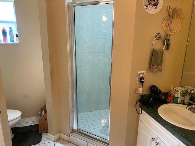 bathroom with tile patterned floors, toilet, vanity, and walk in shower