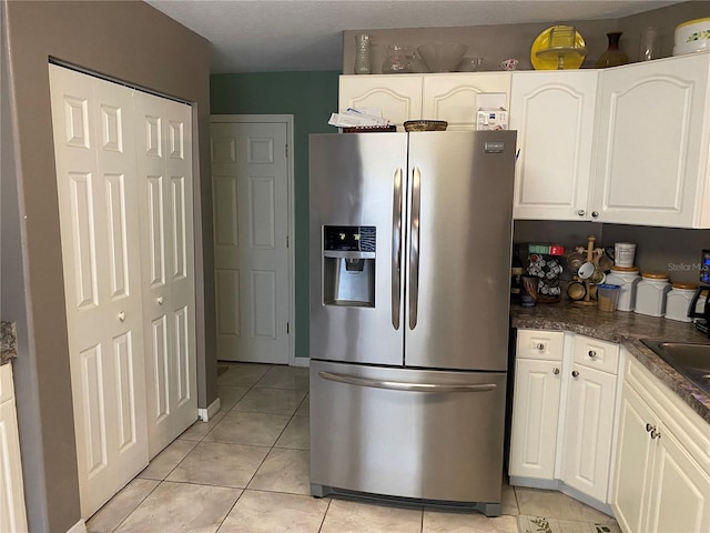 kitchen with white cabinets, stainless steel fridge with ice dispenser, and light tile patterned floors