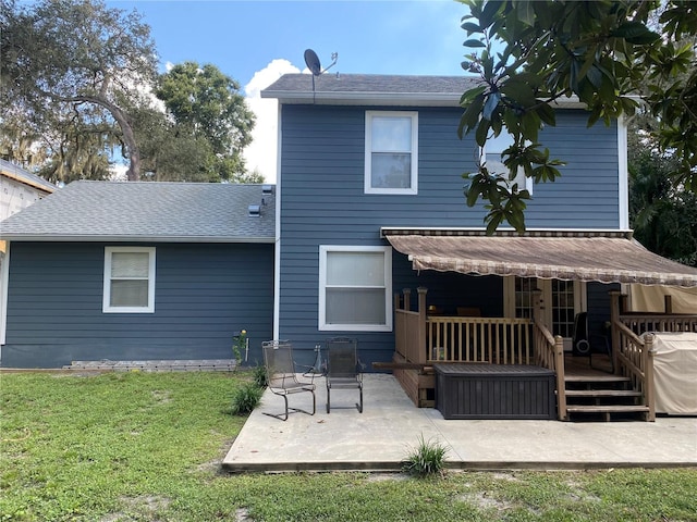 rear view of house with a lawn, a patio, and a wooden deck