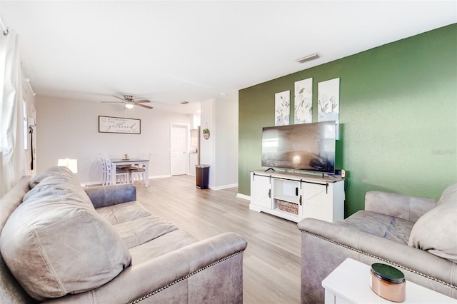 living room featuring ceiling fan and light hardwood / wood-style flooring