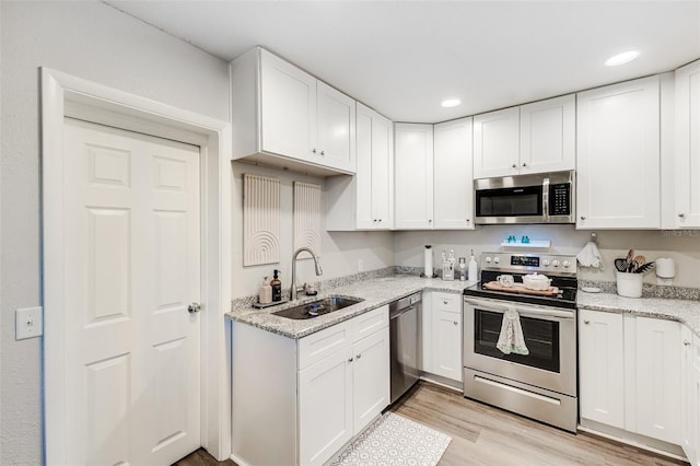 kitchen featuring stainless steel appliances, sink, and white cabinetry