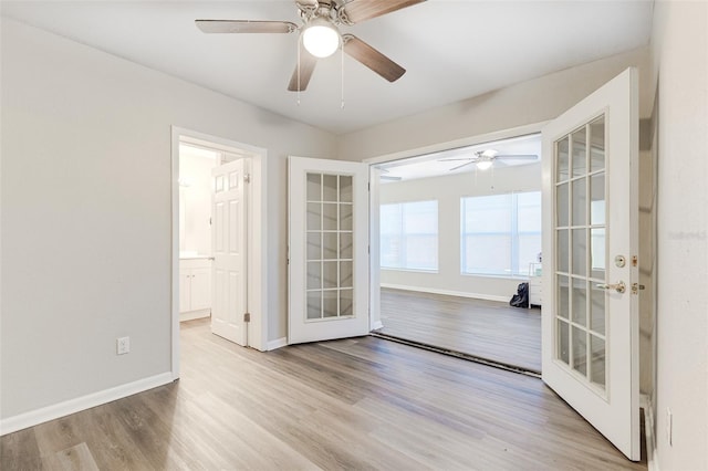 spare room featuring light wood-type flooring, ceiling fan, and french doors