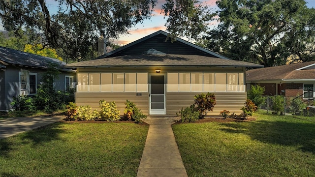 bungalow featuring a sunroom and a yard