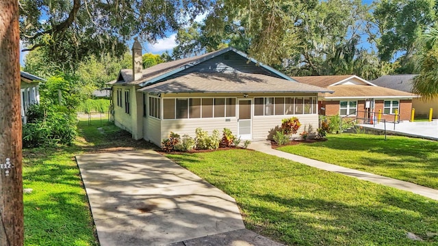 view of front of home with a sunroom and a front yard